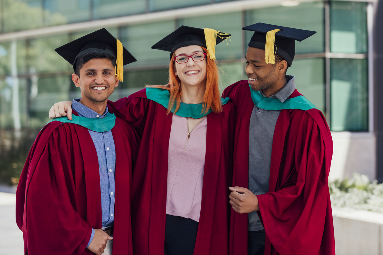 Three graduate students standing outdoors